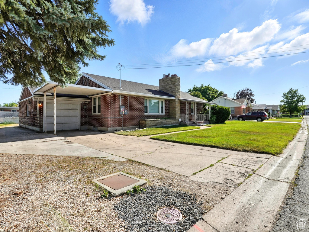 View of front of home with a garage, brick siding, driveway, and a chimney