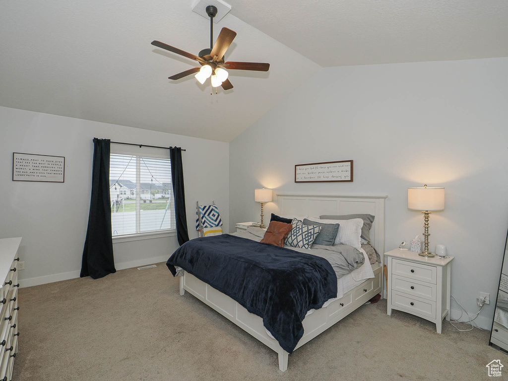 Bedroom featuring vaulted ceiling, light colored carpet, and a ceiling fan