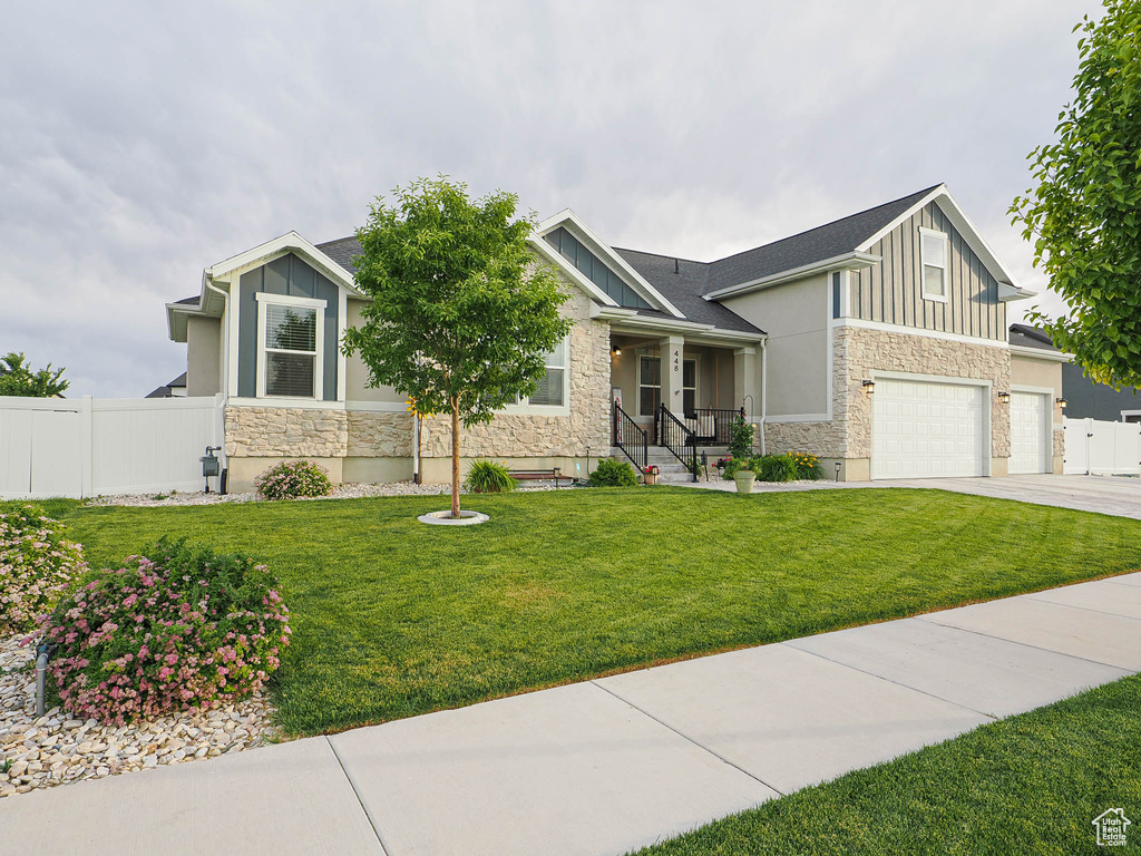Craftsman-style house with stone siding, board and batten siding, and a garage