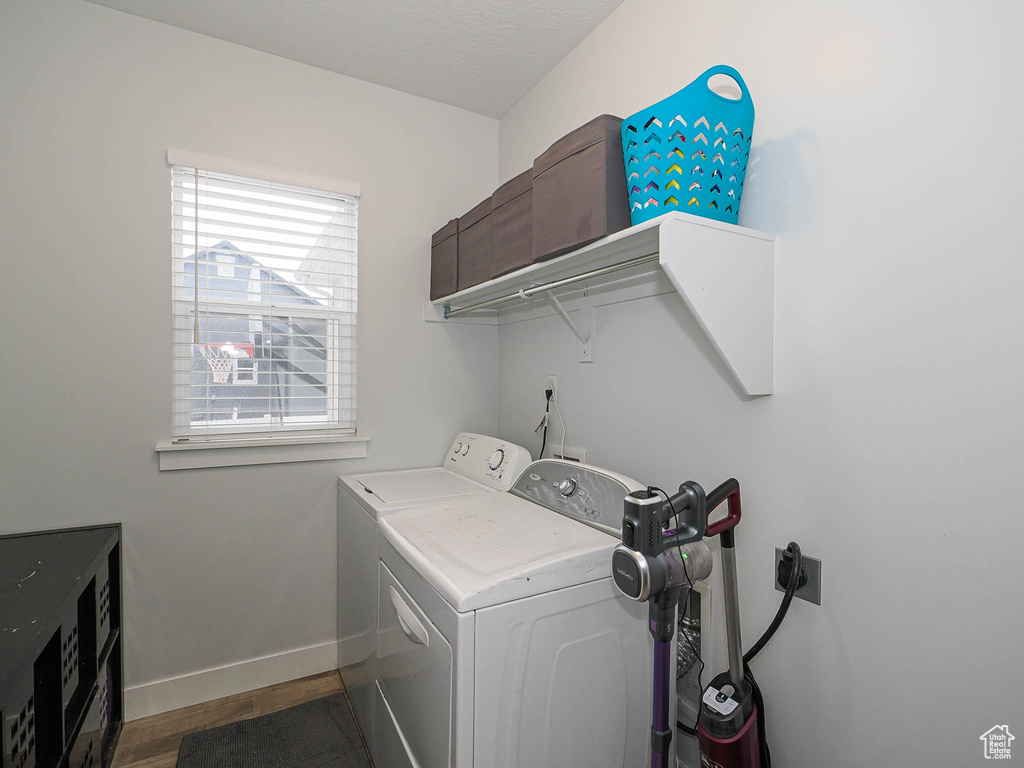 Washroom featuring washer and dryer and wood finished floors