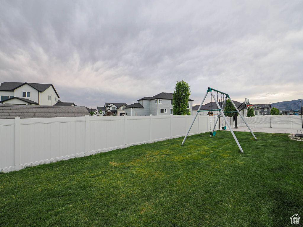 Fenced backyard with a playground and a residential view
