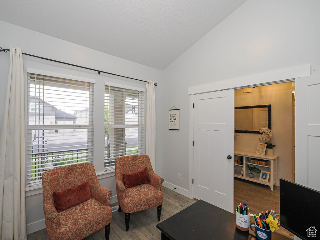 Sitting room with lofted ceiling and wood finished floors