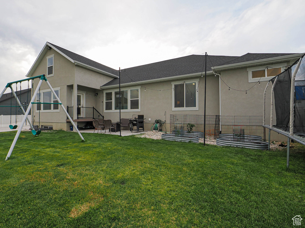 Rear view of house featuring stucco siding, a patio, and a playground