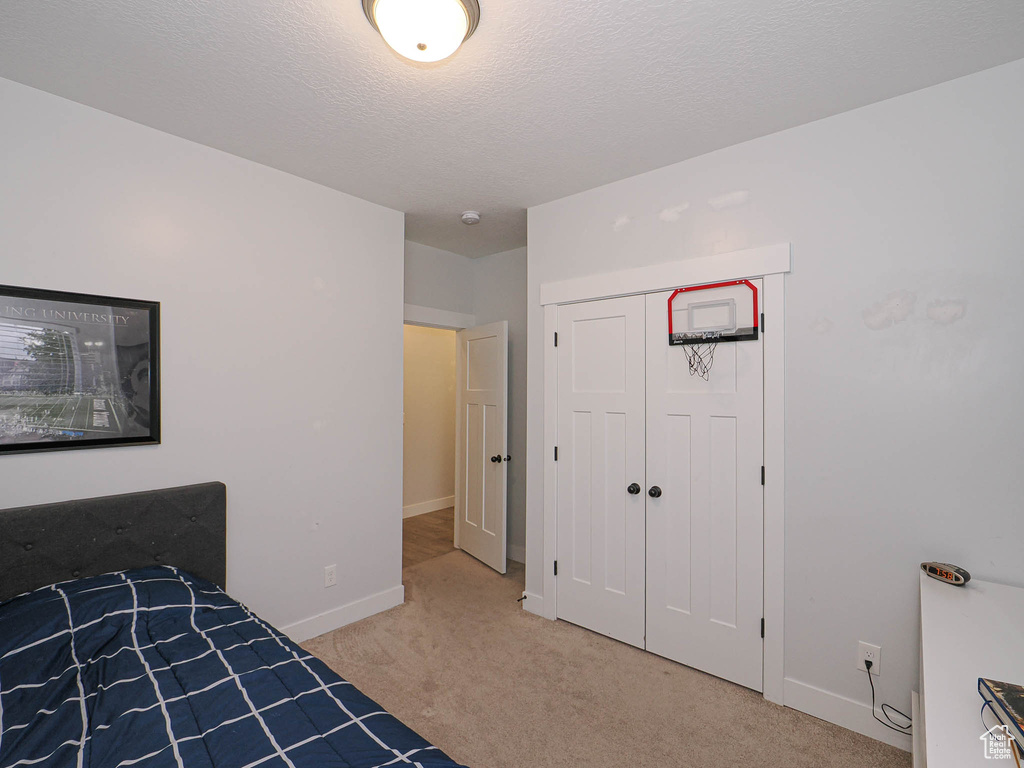 Unfurnished bedroom with light colored carpet and a closet