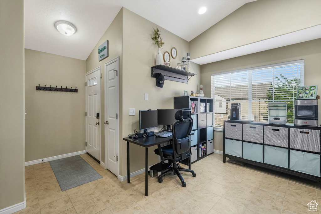 Office featuring lofted ceiling and light tile patterned flooring