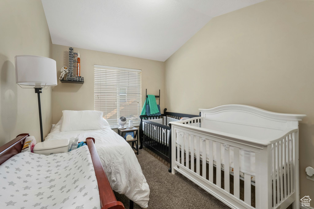 Bedroom featuring vaulted ceiling and carpet