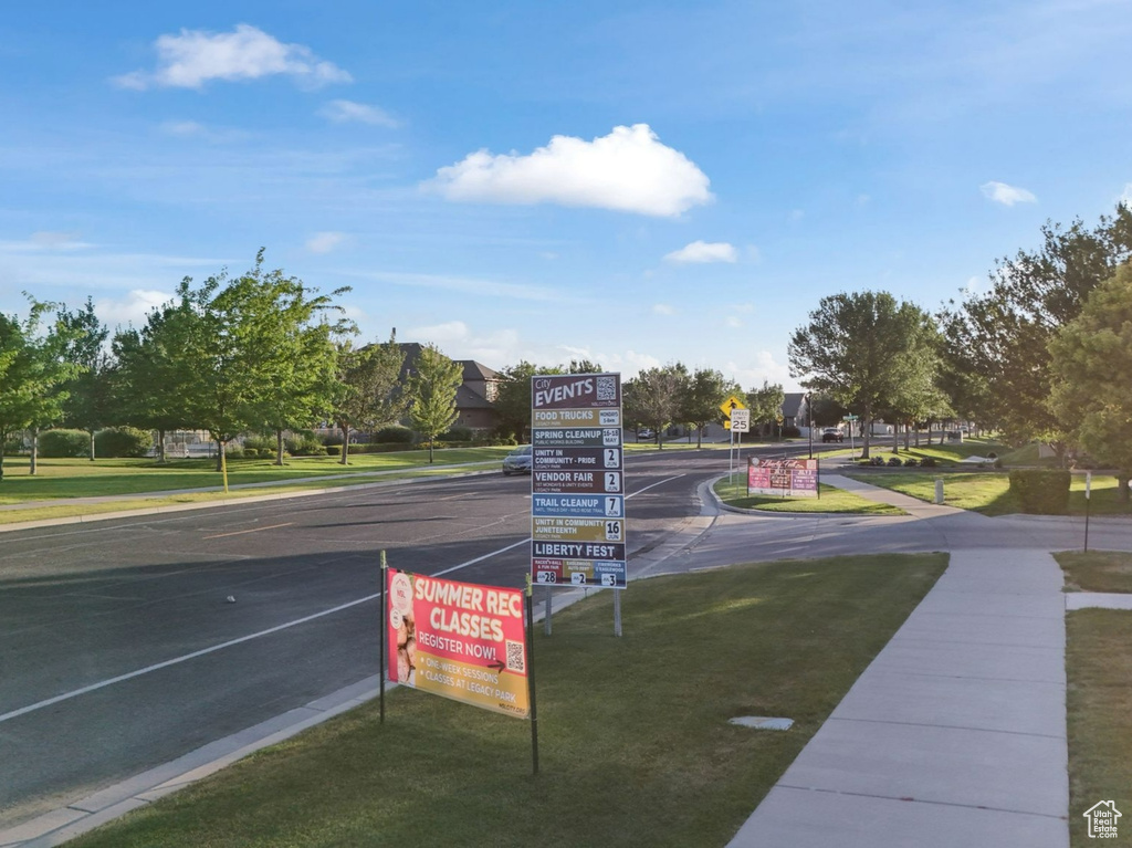 View of asphalt street with sidewalks, traffic signs, and curbs