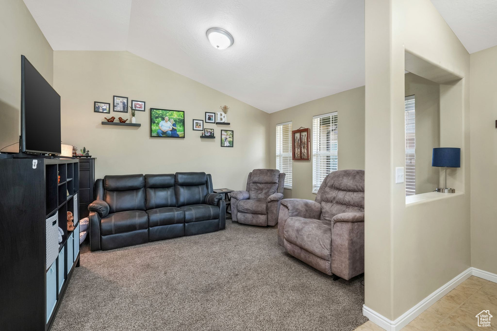 Carpeted living room with lofted ceiling and baseboards