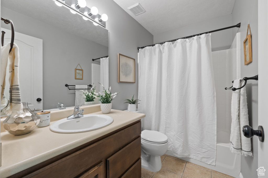 Full bathroom with vanity, tile patterned floors, and shower / tub combo with curtain