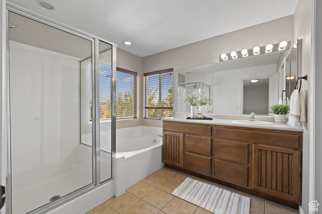 Full bath featuring vanity, a garden tub, a stall shower, and tile patterned flooring