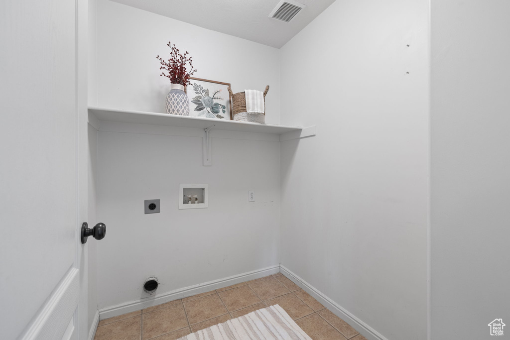 Laundry area featuring hookup for an electric dryer, washer hookup, and light tile patterned floors
