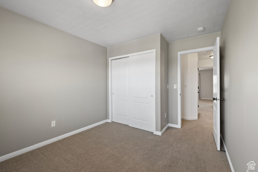 Unfurnished bedroom with carpet and a closet