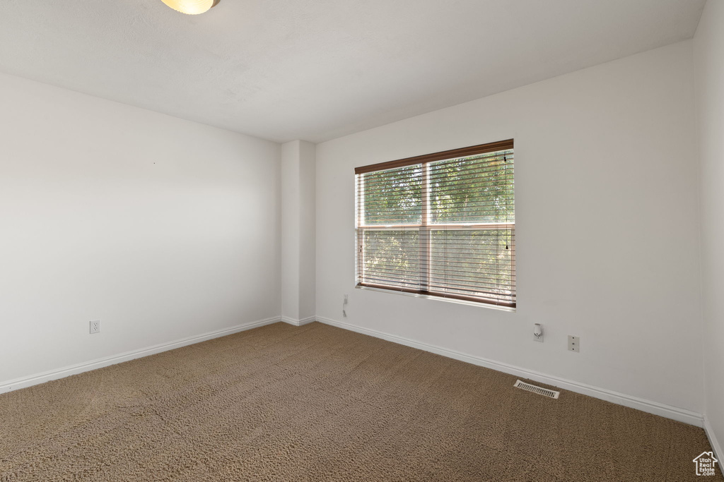 Carpeted spare room with baseboards