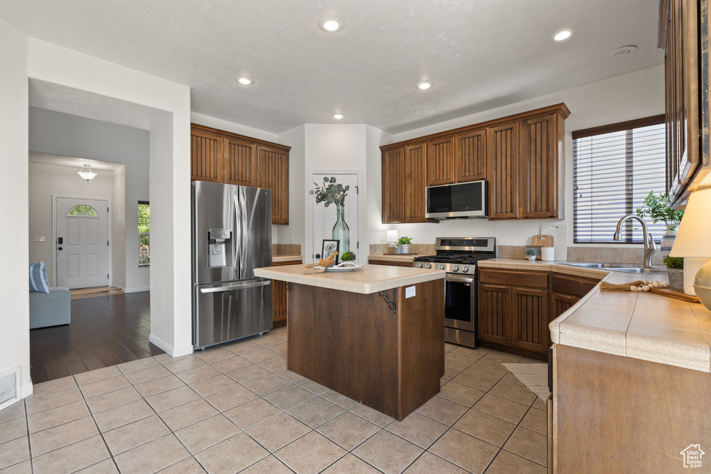 Kitchen featuring appliances with stainless steel finishes, light countertops, healthy amount of natural light, and recessed lighting