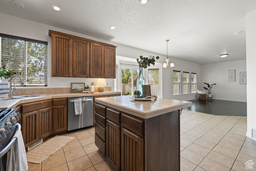 Kitchen with stainless steel appliances, tile countertops, light tile patterned floors, healthy amount of natural light, and recessed lighting
