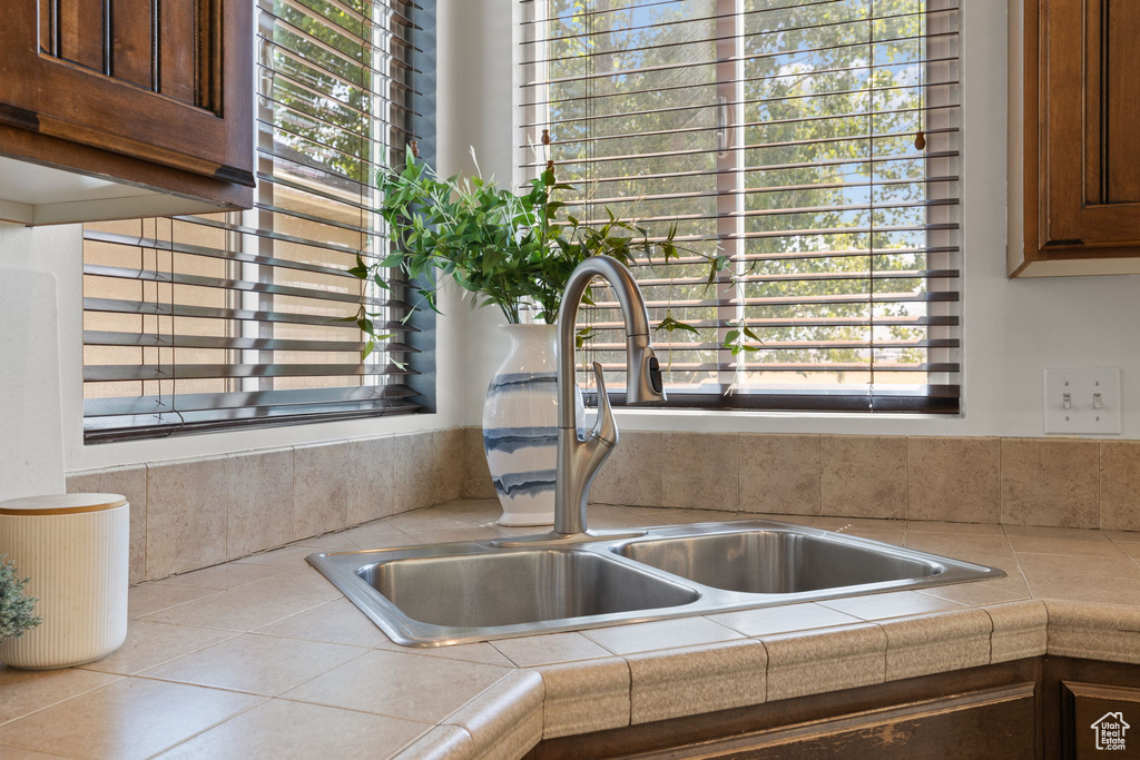 Kitchen view of a sink and tile countertops