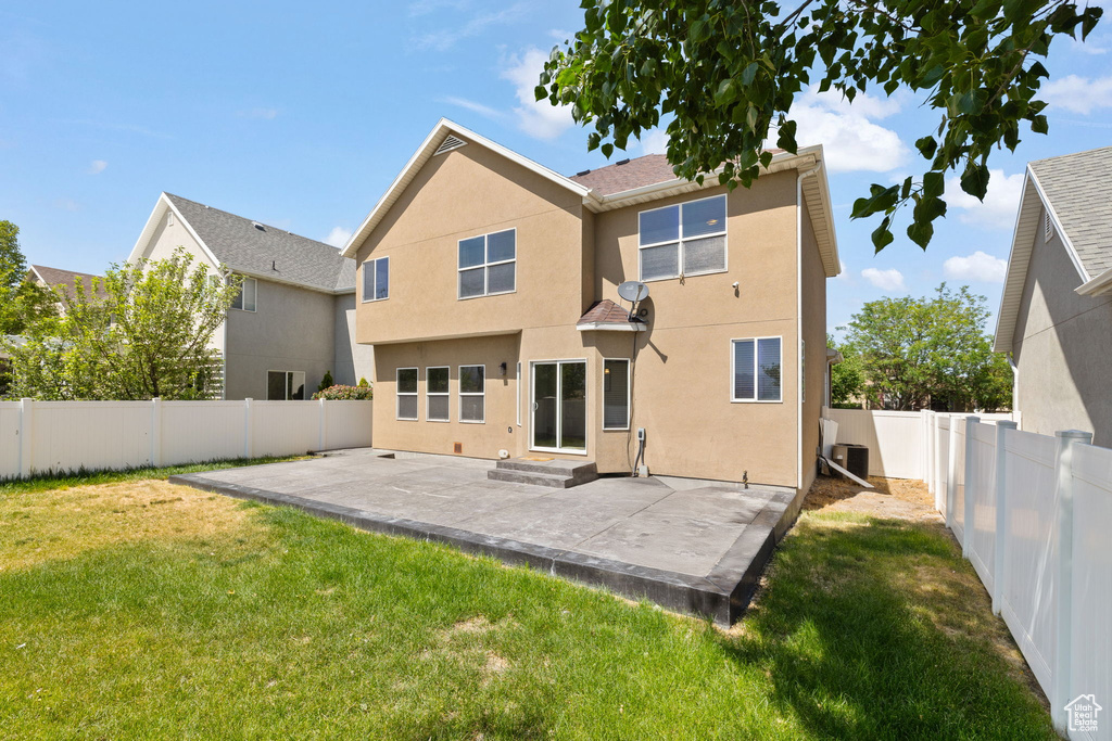 Rear view of house featuring a fenced backyard, a patio area, and stucco siding