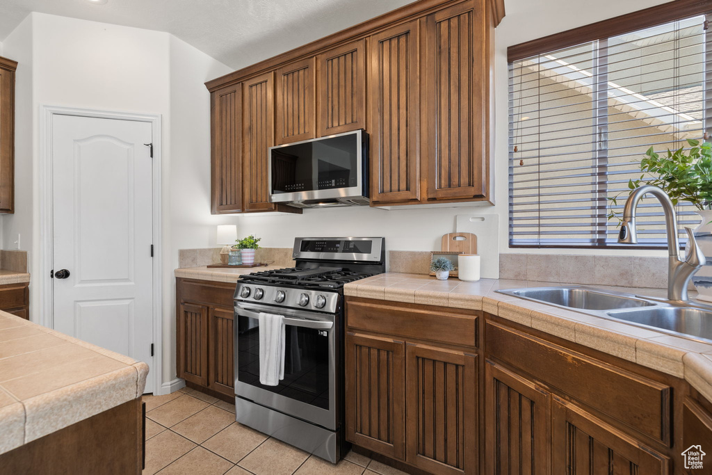 Kitchen with appliances with stainless steel finishes and light tile patterned flooring
