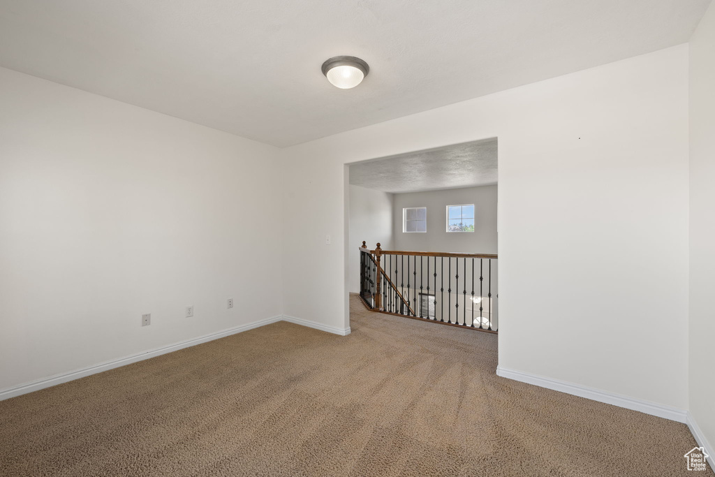 Carpeted empty room with baseboards