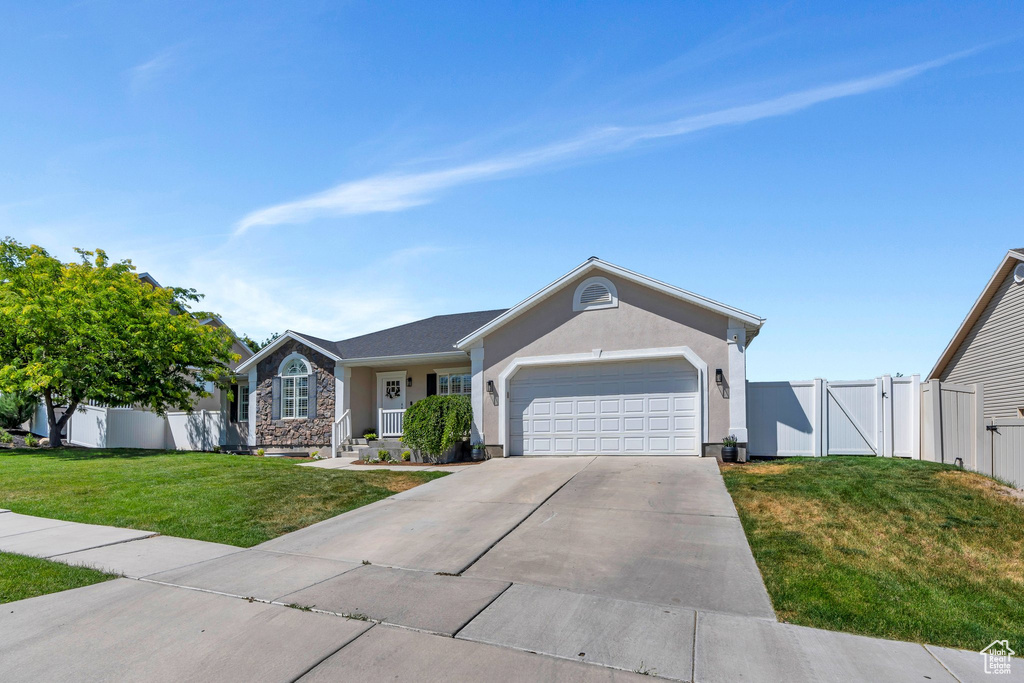 Ranch-style home featuring a gate, a garage, driveway, stucco siding, and stone siding