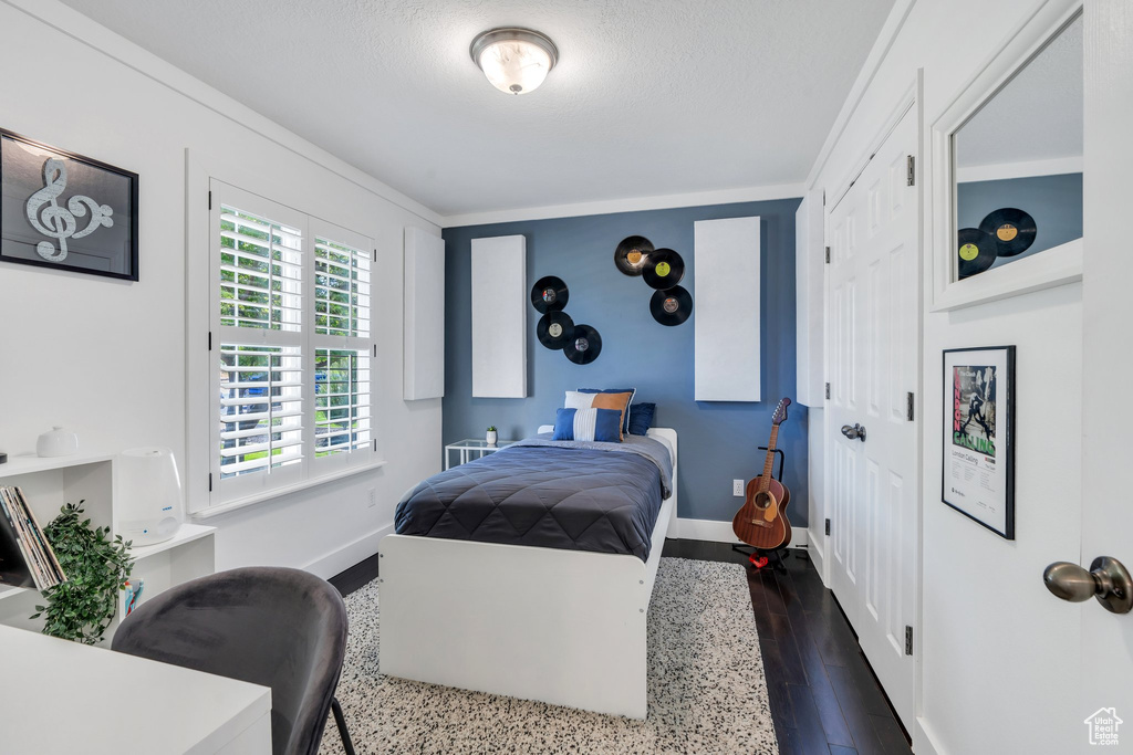 Bedroom with dark wood-type flooring and a textured ceiling