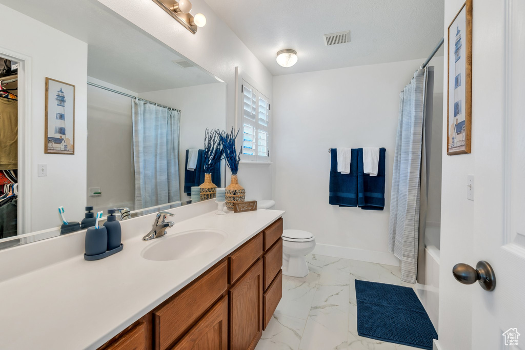Full bath featuring marble finish floors, vanity, and shower / bathtub combination with curtain