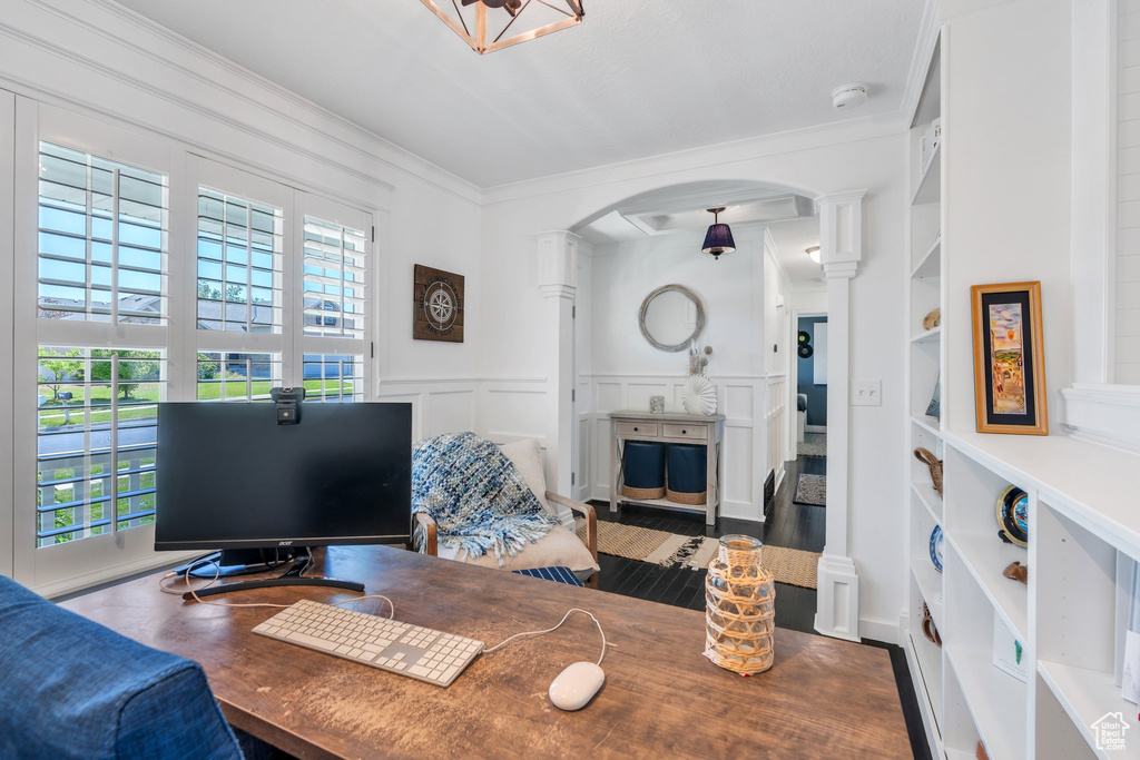 Office space featuring plenty of natural light, arched walkways, built in features, ornate columns, and ornamental molding