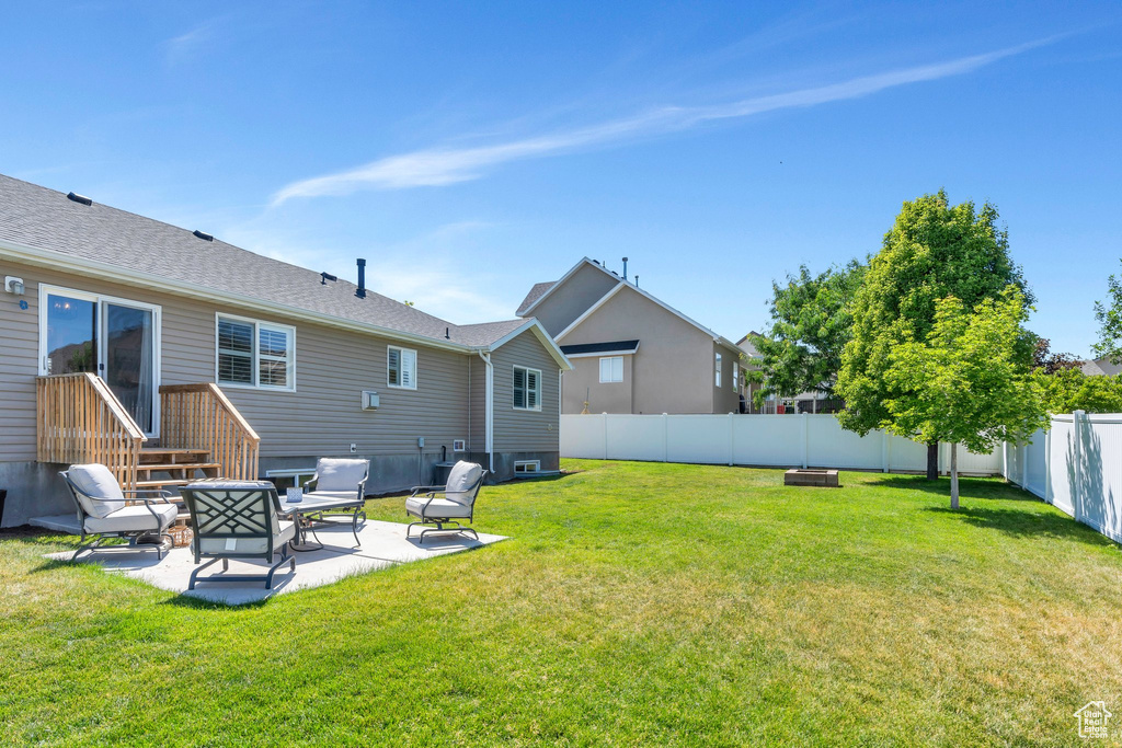 Fenced backyard featuring a patio area and a fire pit