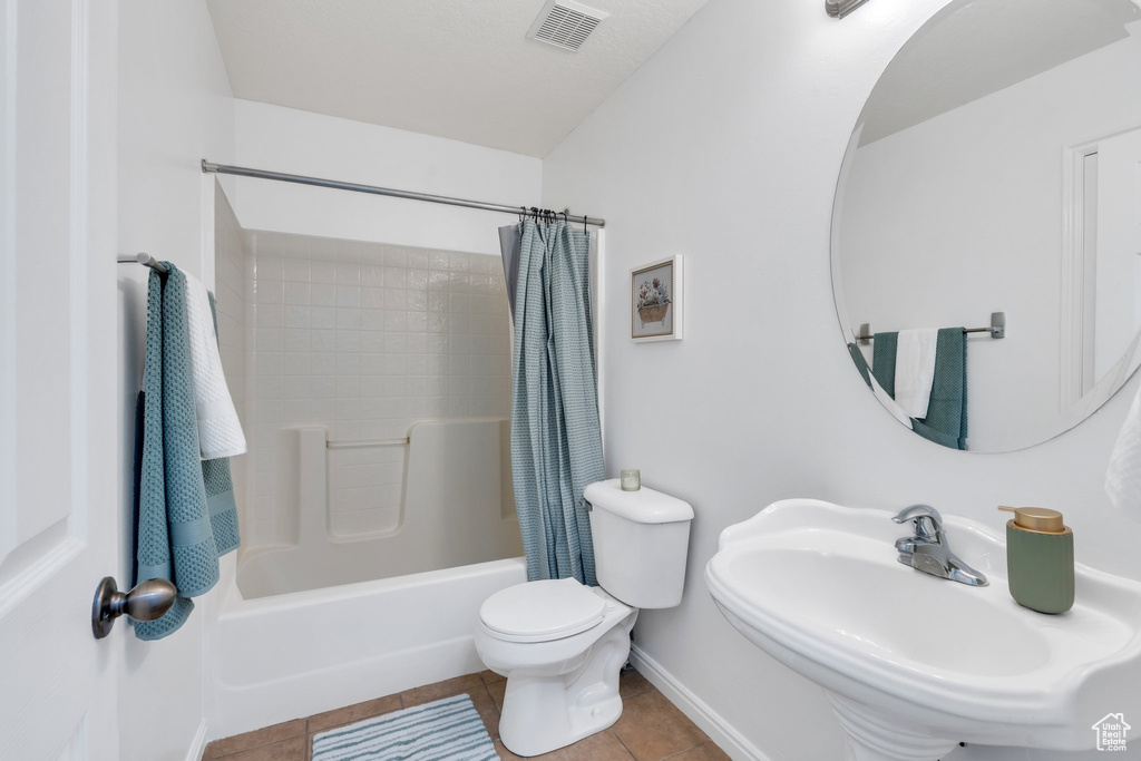 Full bath featuring tile patterned flooring and shower / bath combo with shower curtain