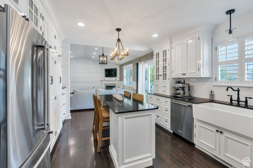 Kitchen featuring stainless steel appliances, dark countertops, plenty of natural light, white cabinetry, and recessed lighting