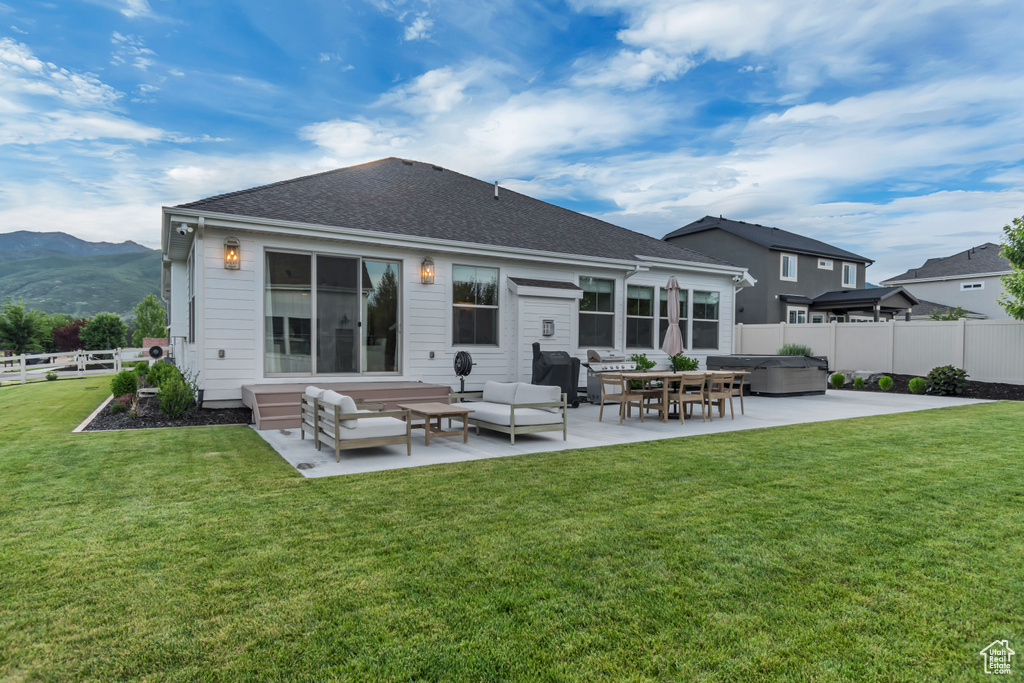 Rear view of house featuring a patio, a hot tub, a fenced backyard, and an outdoor hangout area