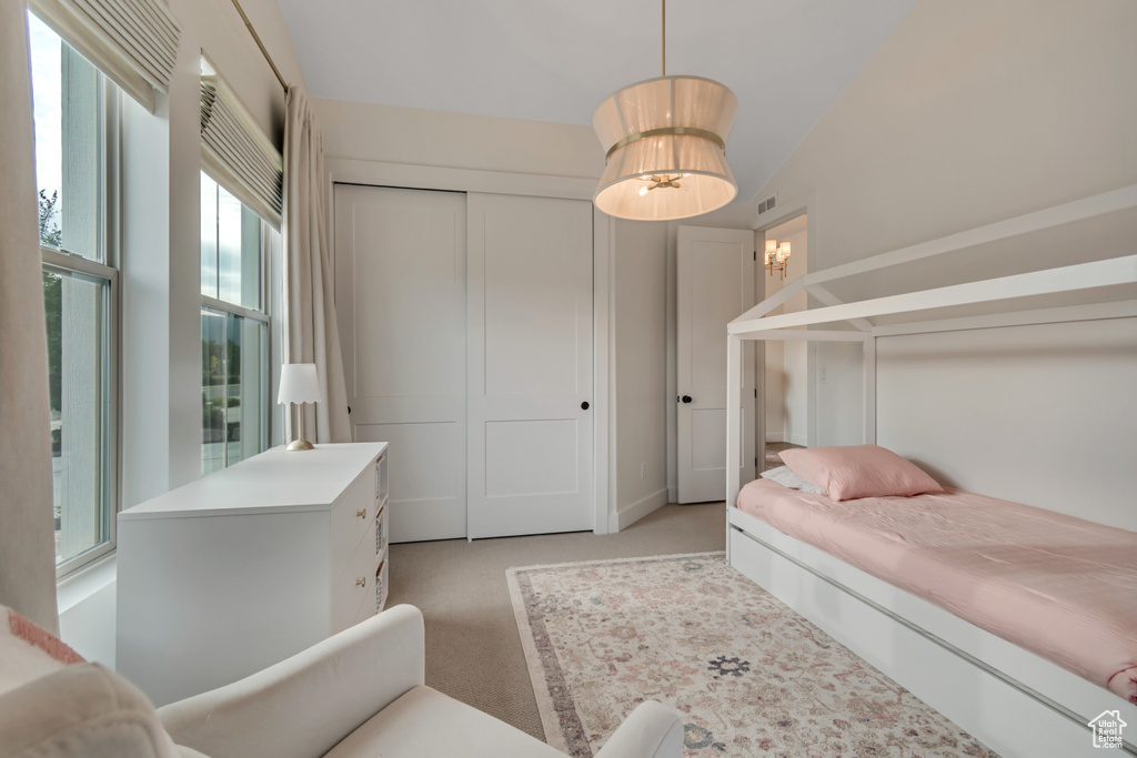 Bedroom featuring light colored carpet and a closet