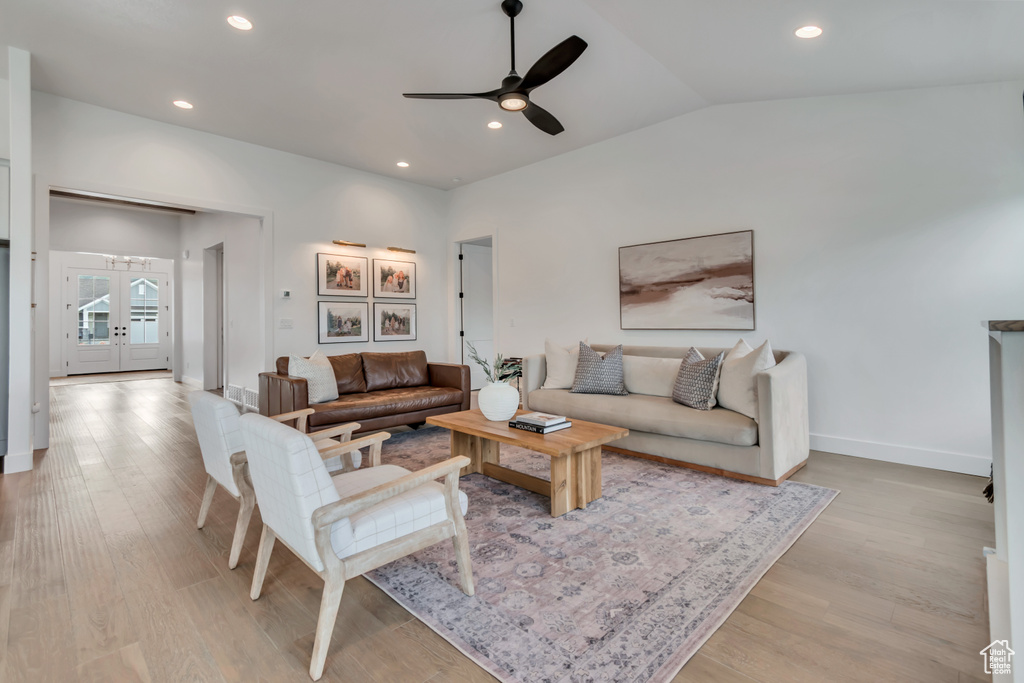 Living room with a ceiling fan, light wood finished floors, vaulted ceiling, and recessed lighting