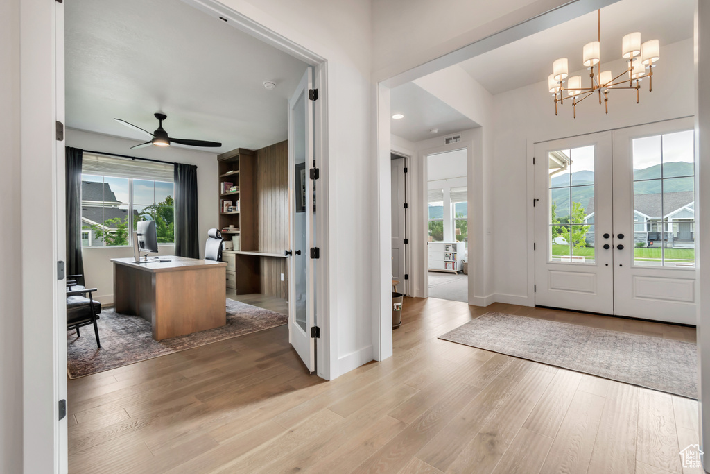 Foyer entrance featuring a chandelier, light wood-type flooring, french doors, and ceiling fan