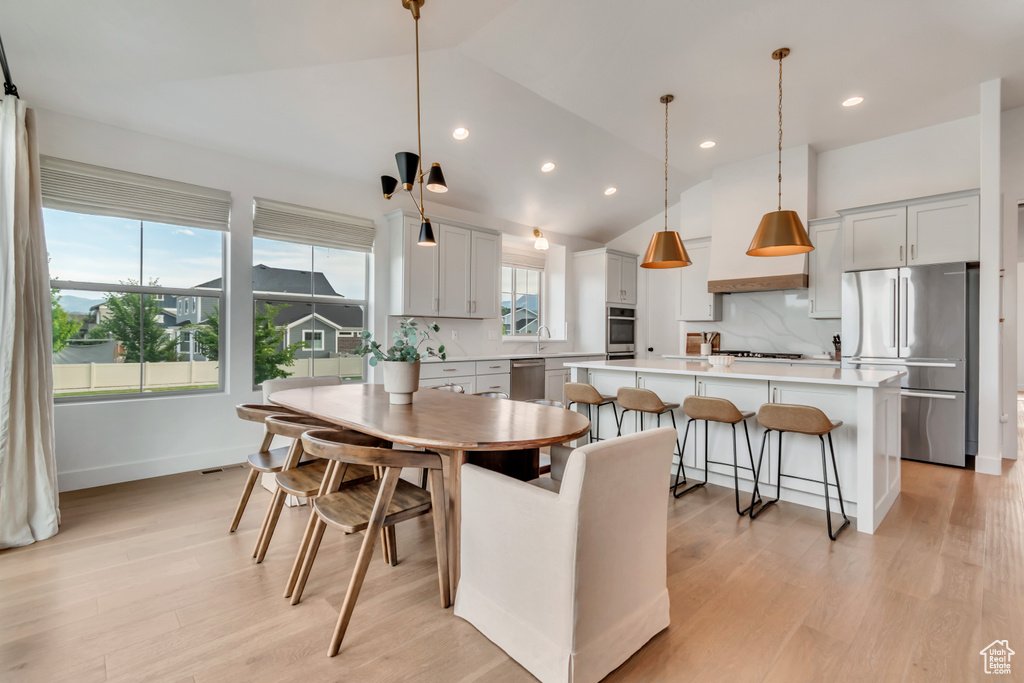 Dining area with light wood finished floors, recessed lighting, and lofted ceiling