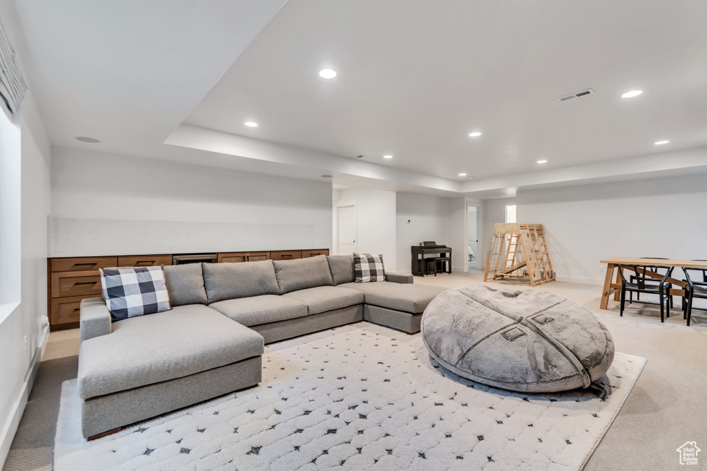 Living area featuring light colored carpet and recessed lighting