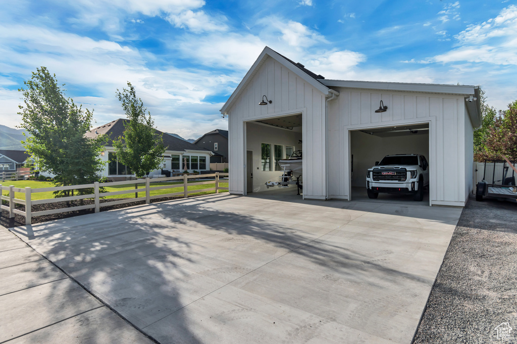 View of side of home with driveway, board and batten siding, and an outdoor structure