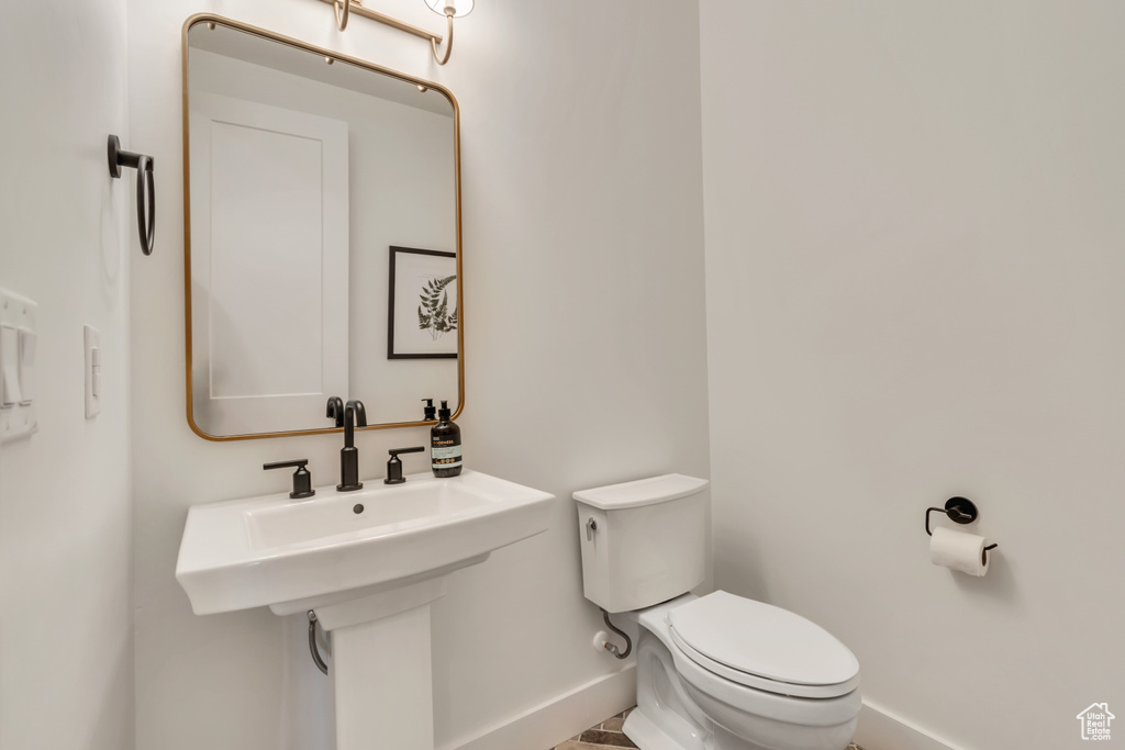 Bathroom featuring baseboards and toilet