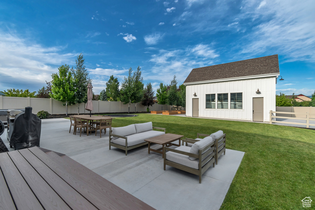 Wooden deck featuring an outdoor hangout area, outdoor dining area, a fenced backyard, and a patio