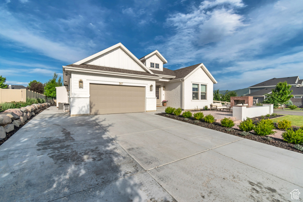 View of front of home with driveway, an attached garage, and board and batten siding