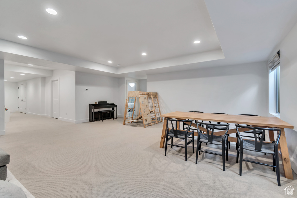 Dining space featuring recessed lighting, light colored carpet, a raised ceiling, and bar area