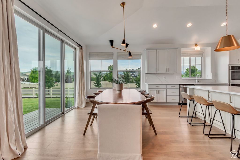 Dining area featuring light wood-style floors, recessed lighting, and vaulted ceiling