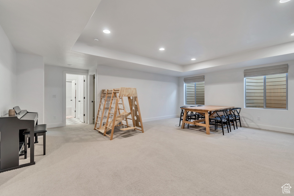Carpeted dining area featuring a tray ceiling and recessed lighting