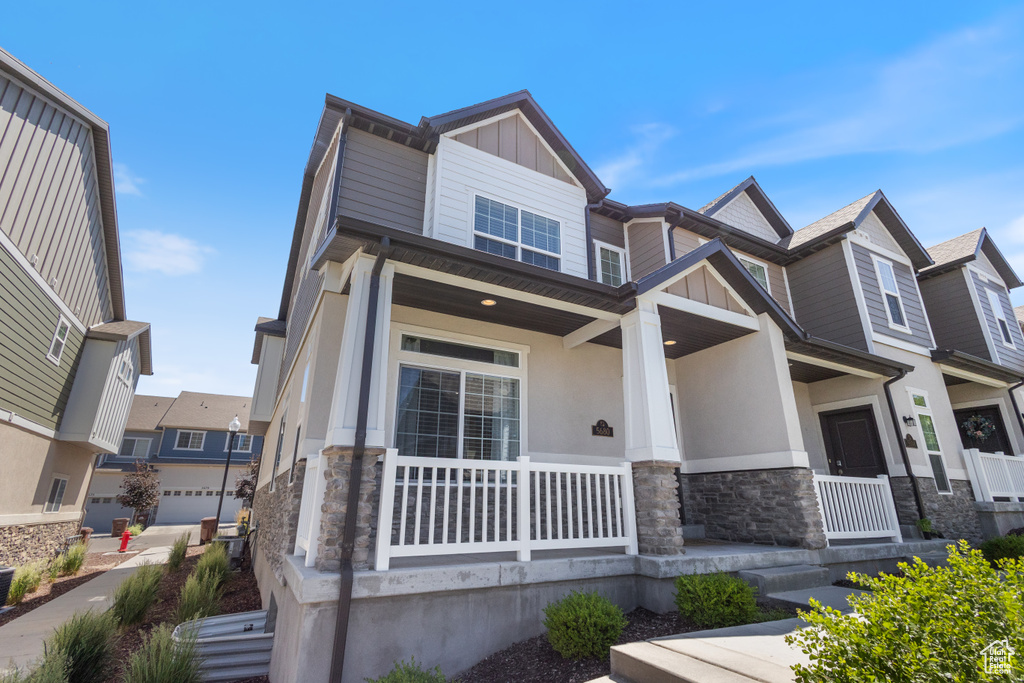 Craftsman-style house with stone siding, covered porch, and stucco siding