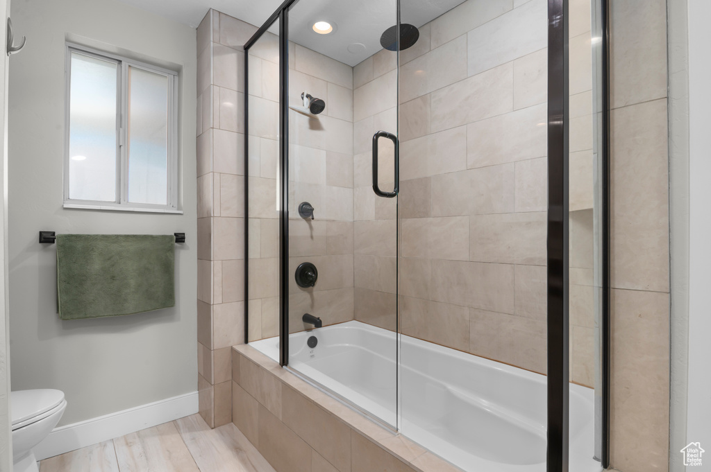 Bathroom with toilet and a combined bath / shower with rainfall shower
