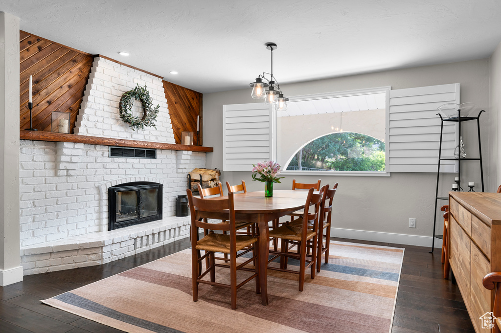 Dining room with wood finished floors, a fireplace, recessed lighting, and wood walls