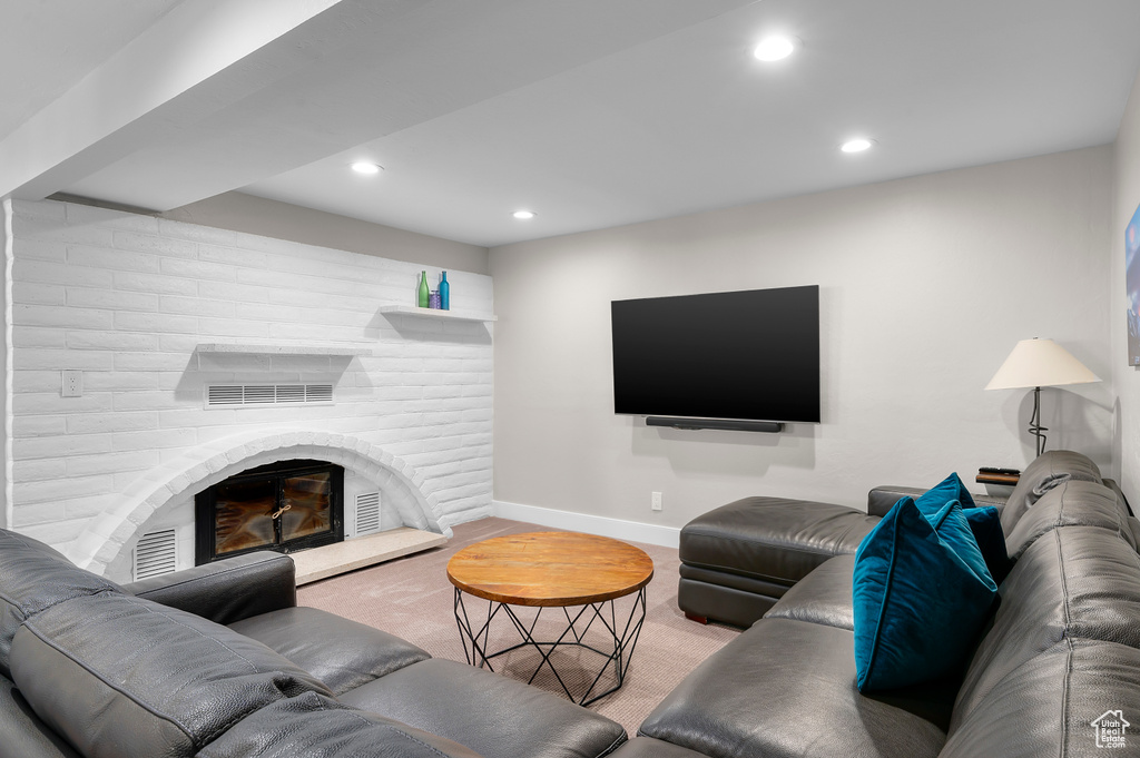 Living room with carpet flooring, a brick fireplace, and recessed lighting