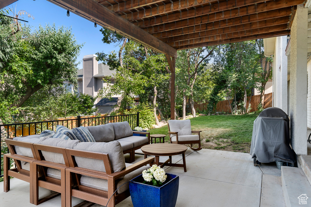 Fenced backyard with grilling area, an outdoor hangout area, and a patio