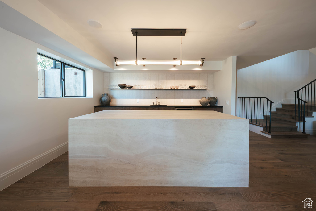 Kitchen with a center island and dark wood-type flooring