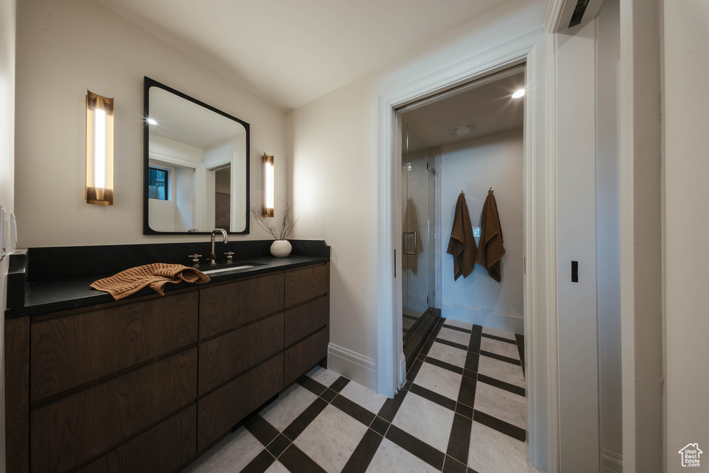 Full bath with vanity, inlaid floor details, a shower stall, and tile patterned floors